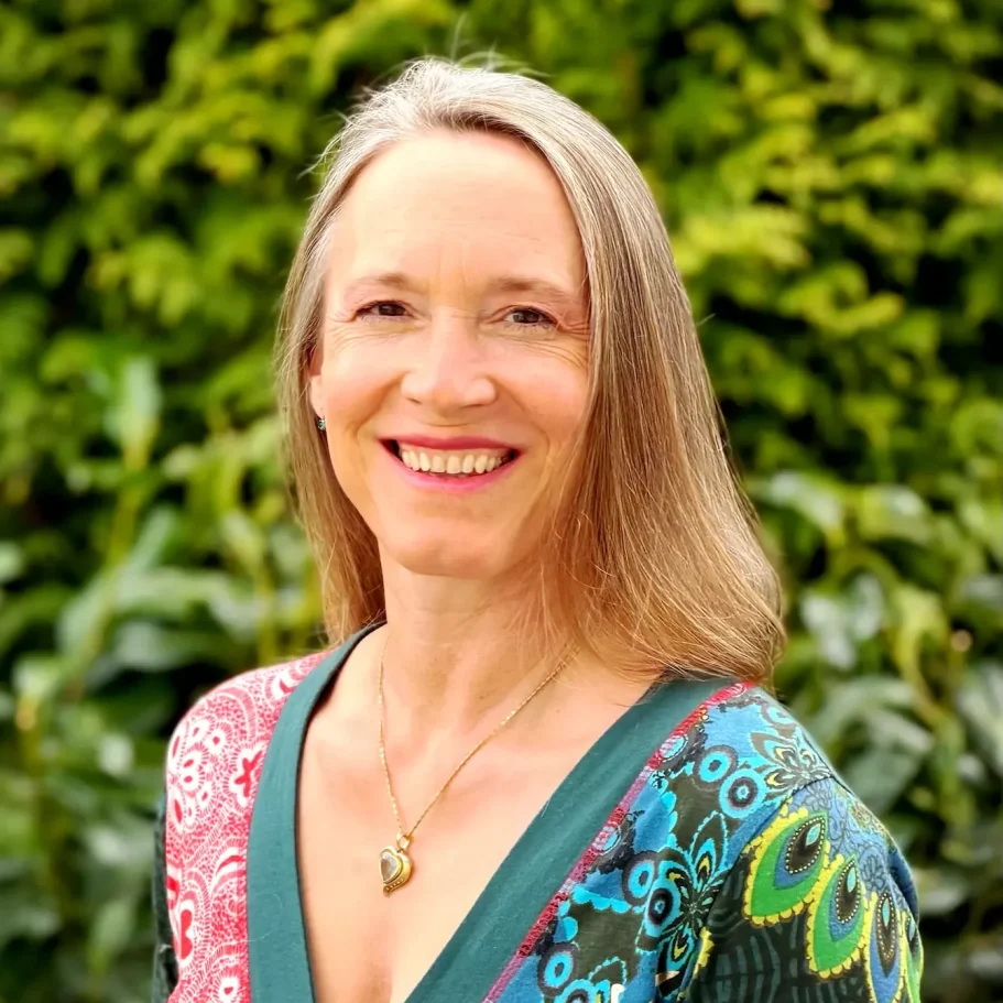 Portraitfoto Dr. Katja Eissfeldt: Licht und Schattenspiel auf natürlichem Portrait, lächelnd, Haare offen & Kleid bunt, Ich-bin-was-ich-Bin